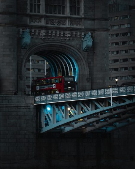 Een rode dubbeldeksbus rijdt onder de Tower Bridge in Londen.